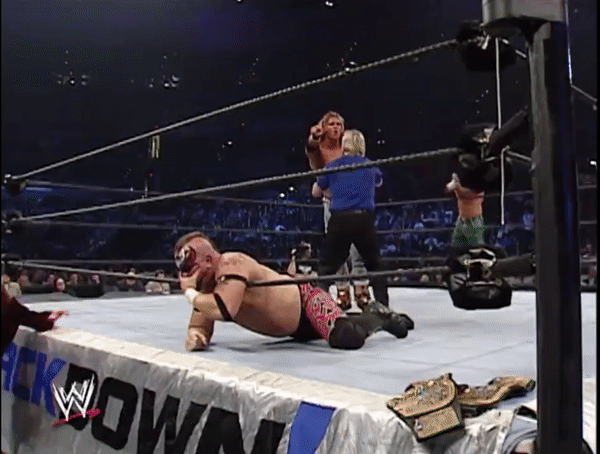 Taking advantage of his exhaustion as he rests on the bottom rope, you pounce, wrapping your legs around his neck and the rope, squeezing him out.