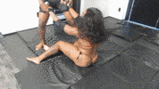 Wrapping your arms around her midsection, you lift her high into the air.  You position her head between your knees and then drive her down hard into the mats. 